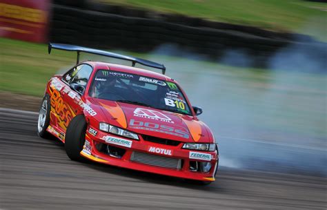 Fotografía de un coche de drift ejecutando un sobreviraje controlado.