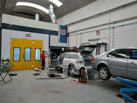 Taller de chapa y pintura con coche en proceso de reparación