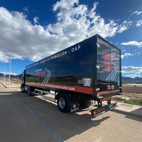 Un camión moderno rotulado con un diseño corporativo llamativo