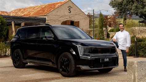 Mario Sandoval sonriendo junto a un Kia EV9