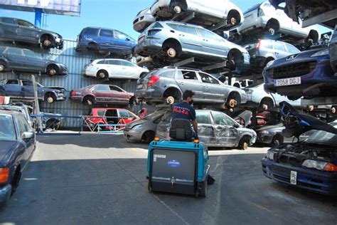 Fotografía de varios cubrecarters de diferentes modelos de coche en un desguace.
