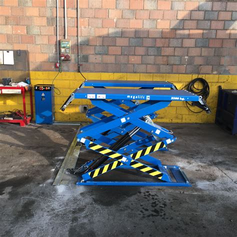 Imagen de un elevador de coches en un taller mecánico.