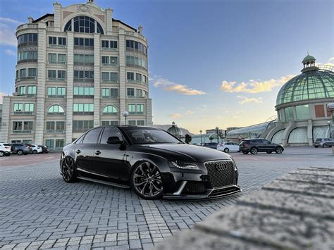 Fotografía de un coche de lujo aparcado frente a un edificio moderno y elegante