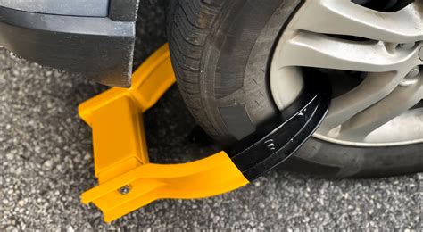 Fotografía de un coche con un cepo de rueda instalado
