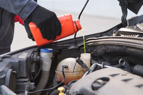 Persona llenando el depósito de refrigerante de una motocicleta con un embudo