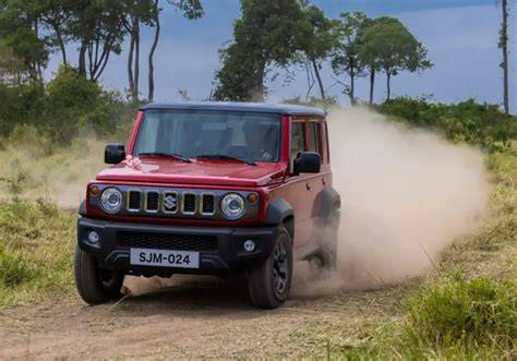 Un Suzuki Jimny transitando por un sendero estrecho en el bosque