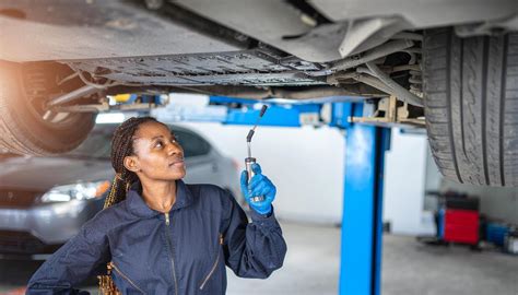 Mecánico inspeccionando un coche en un centro de compra