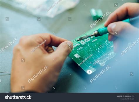 Mano inspeccionando un componente electrónico