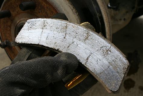 Primer plano de pastillas de freno desgastadas y un disco de freno rayado