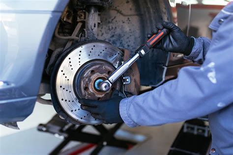 Mecánico inspeccionando frenos de un coche